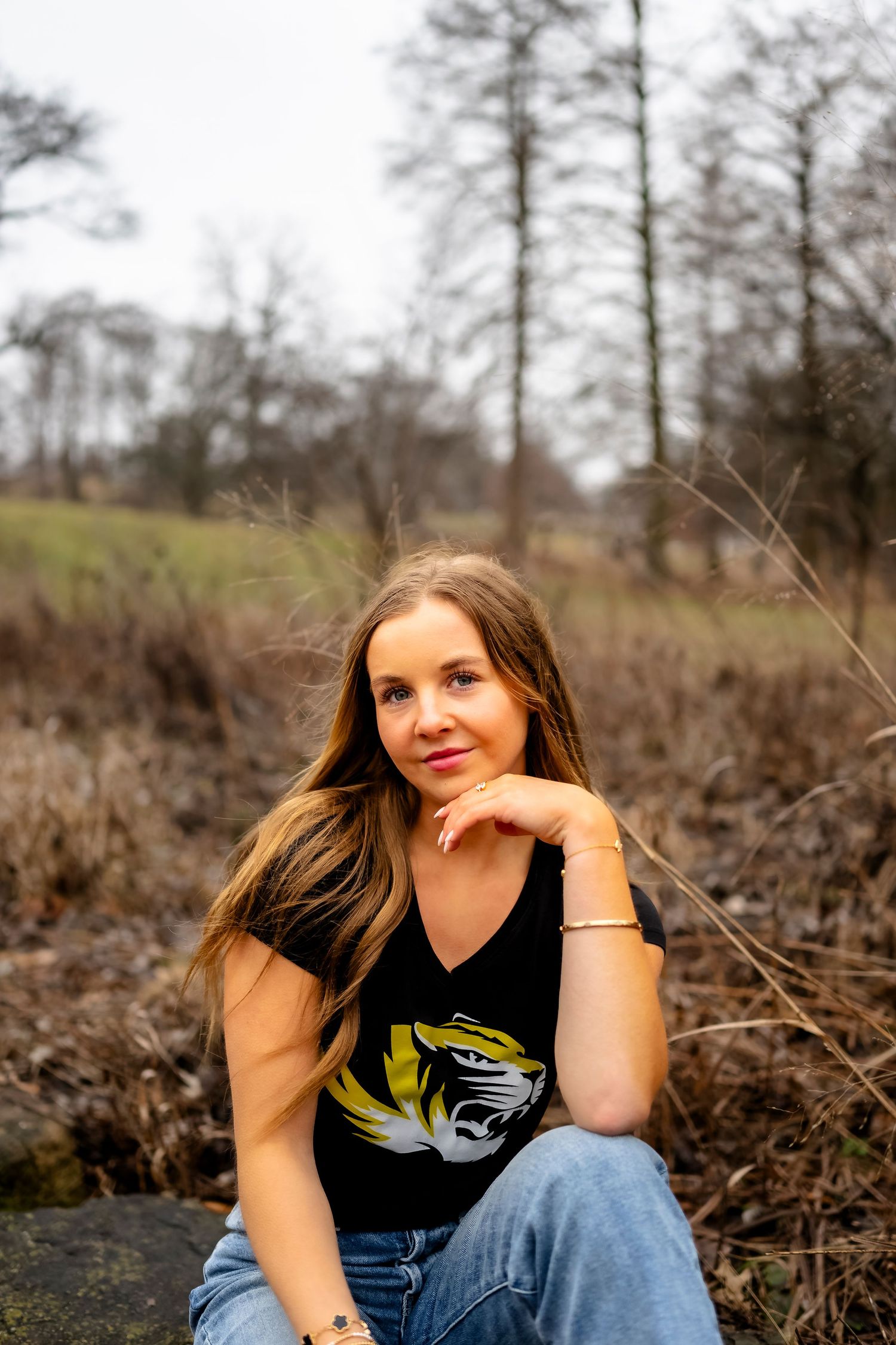 A casual outdoor portrait taken against a natural winter landscape.
