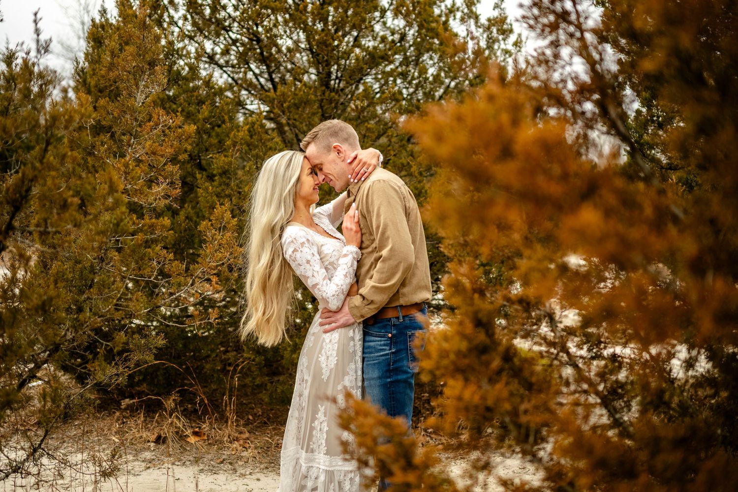 A romantic outdoor photo session among fall-colored trees and brush.