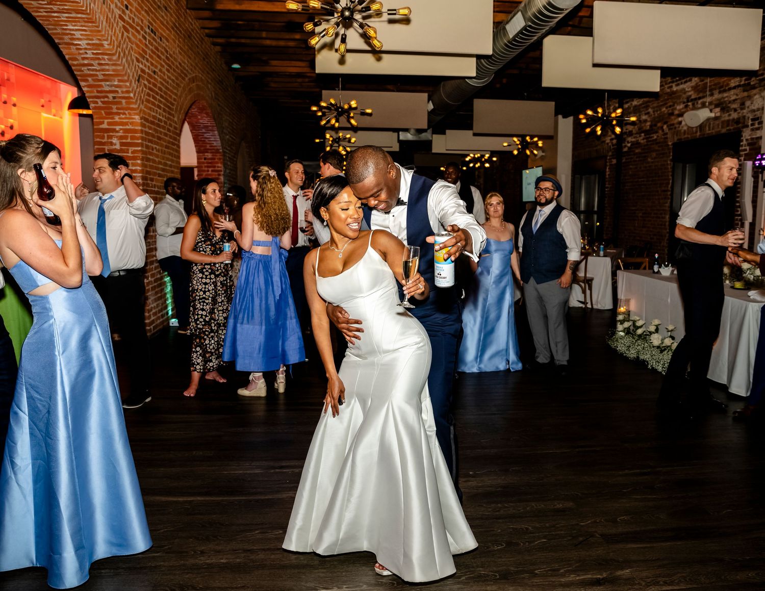 Wedding reception dance floor with guests in blue bridesmaid dresses and formal attire.