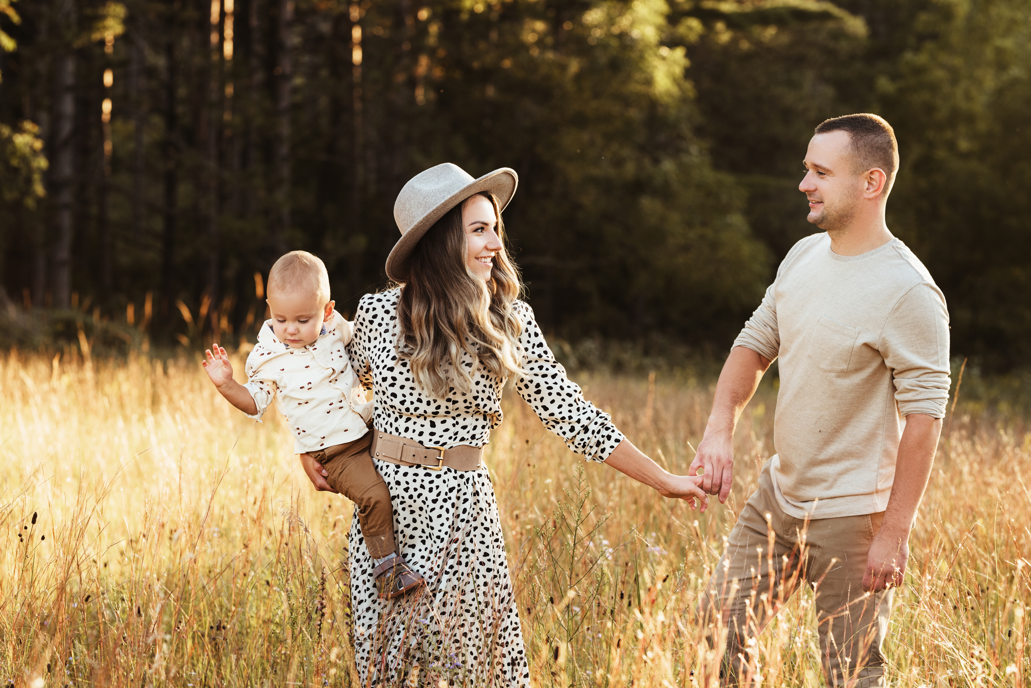 Family of three walking through the fields in a forest