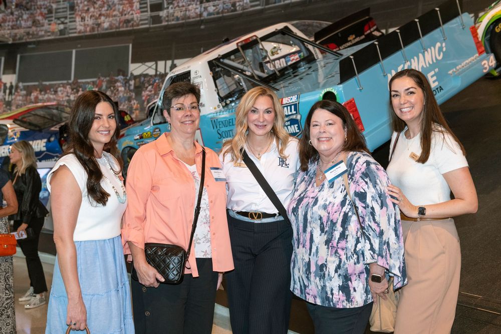 A group of people gathered at an event wearing casual attire and smiling together.