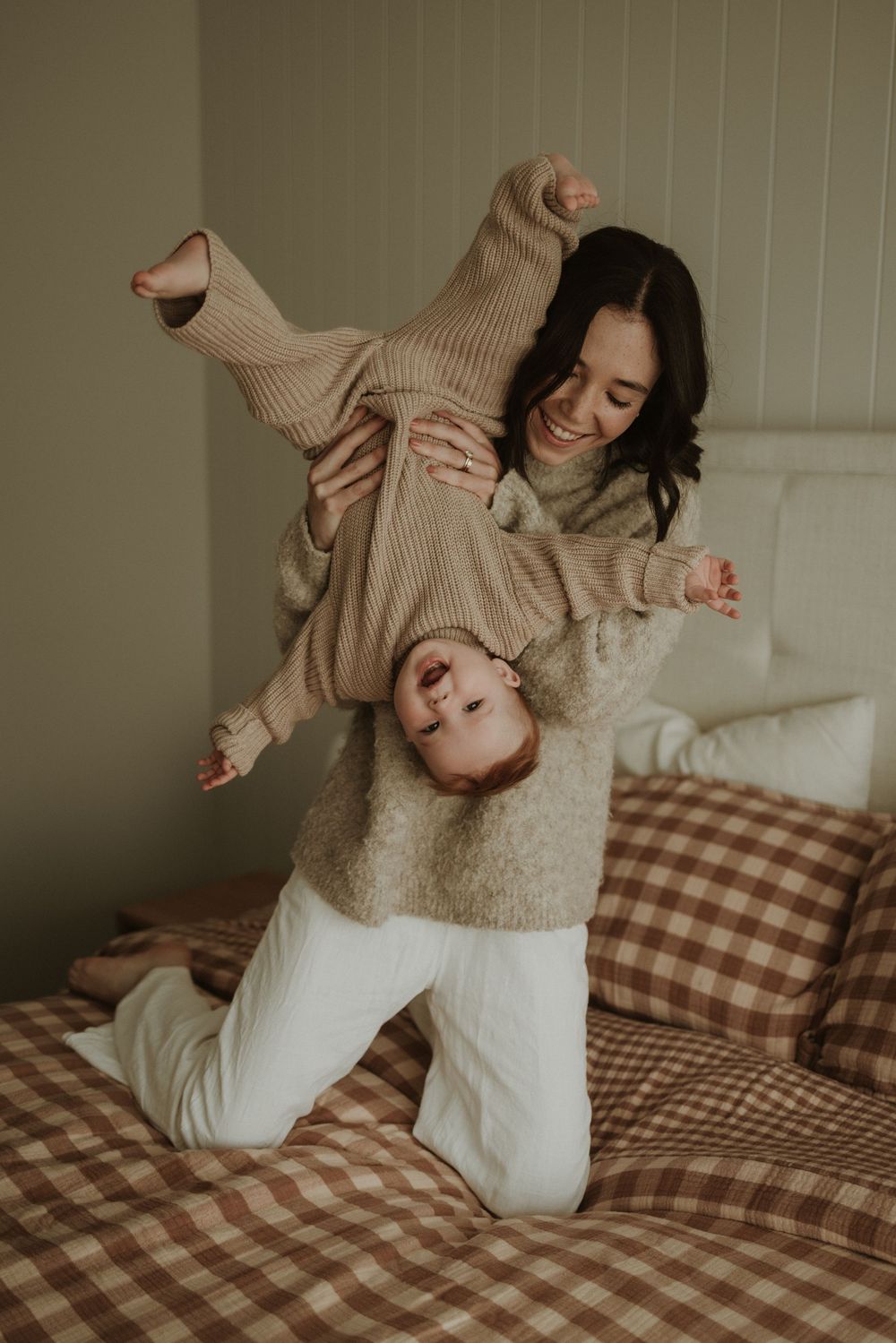 A sequence of playful moments on a bed with gingham pattern bedding, showing joyful movement and comfort.