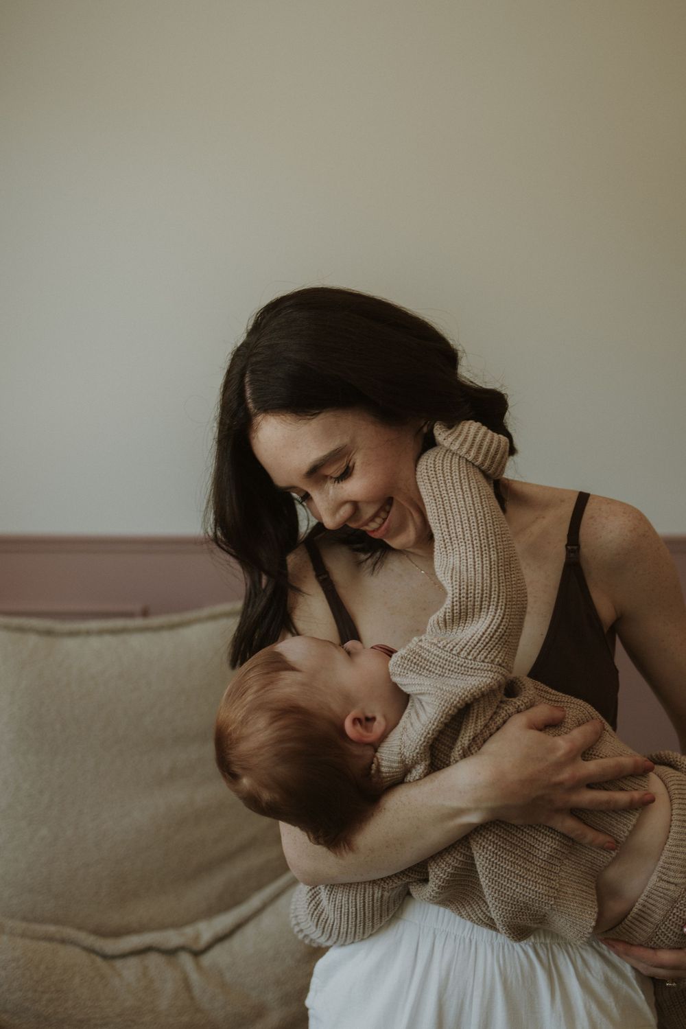 Tender moments captured in warm light showing affectionate interaction on a cozy couch.