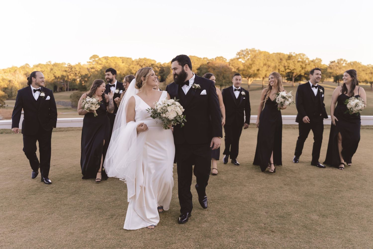 Bride and Groom walking with their bridal party during wedding party photos at Myers Park Country Club.