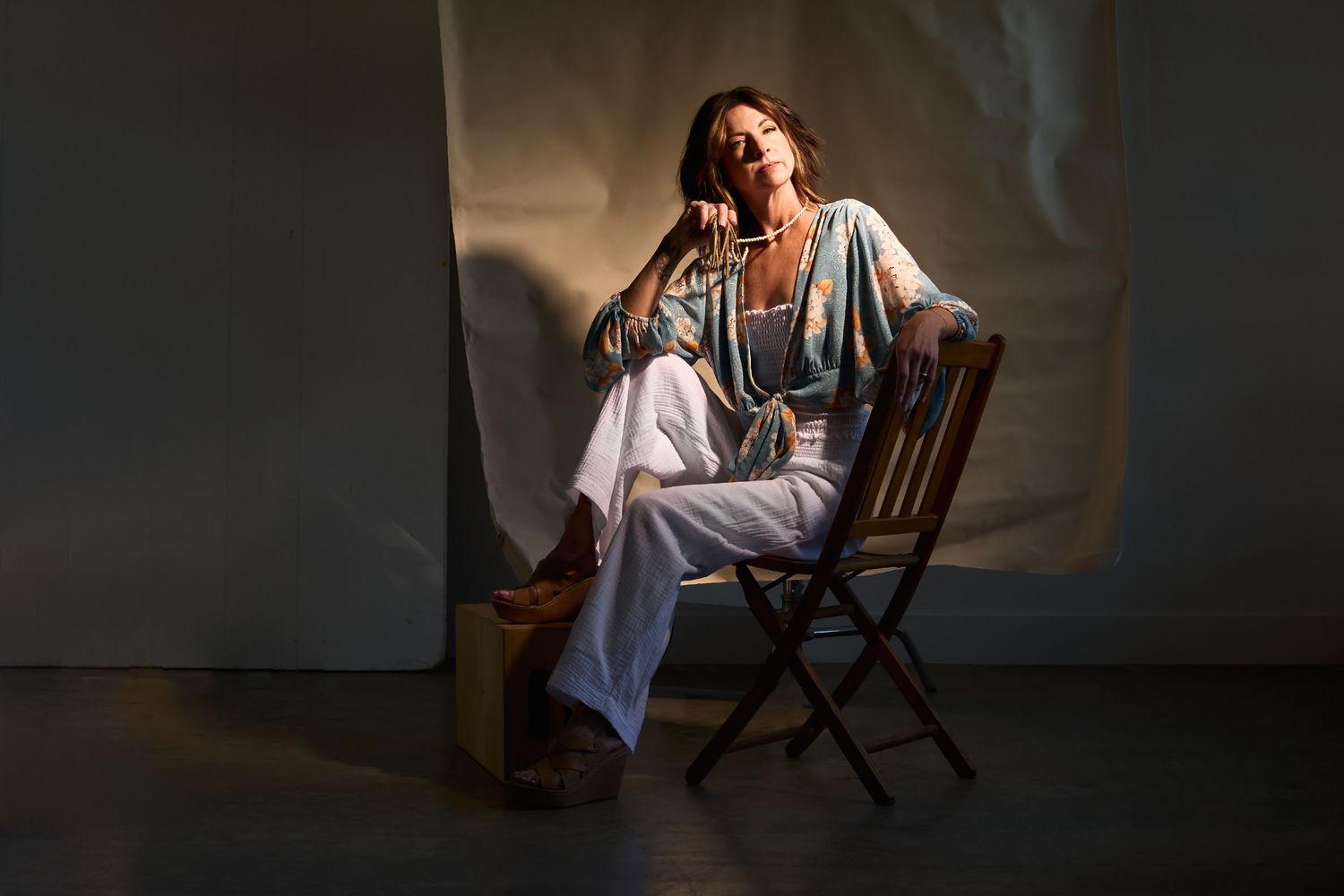 Dramatic studio lighting setup with chair and dark background.