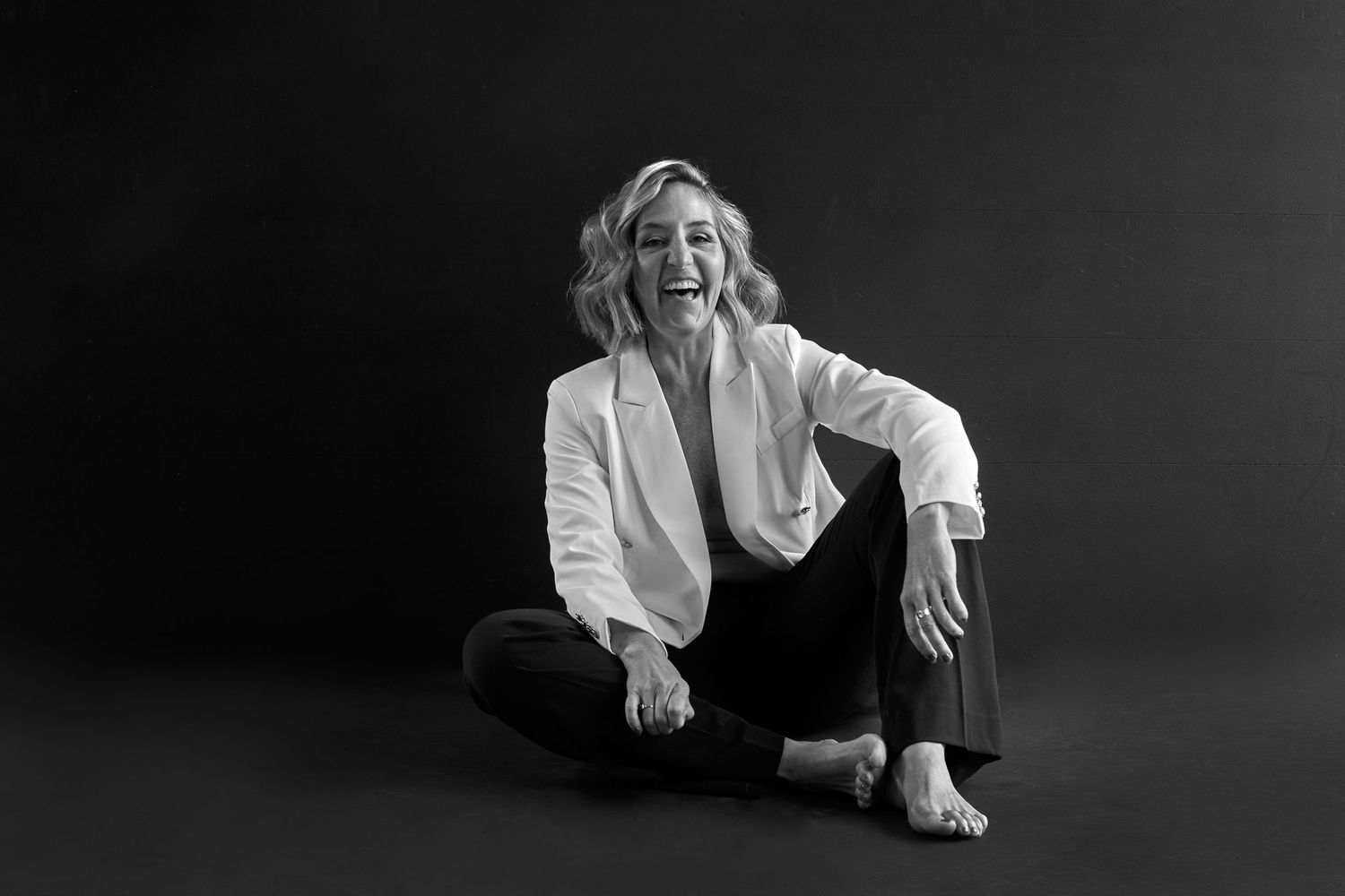 Black and white portrait session in minimalist studio setting.