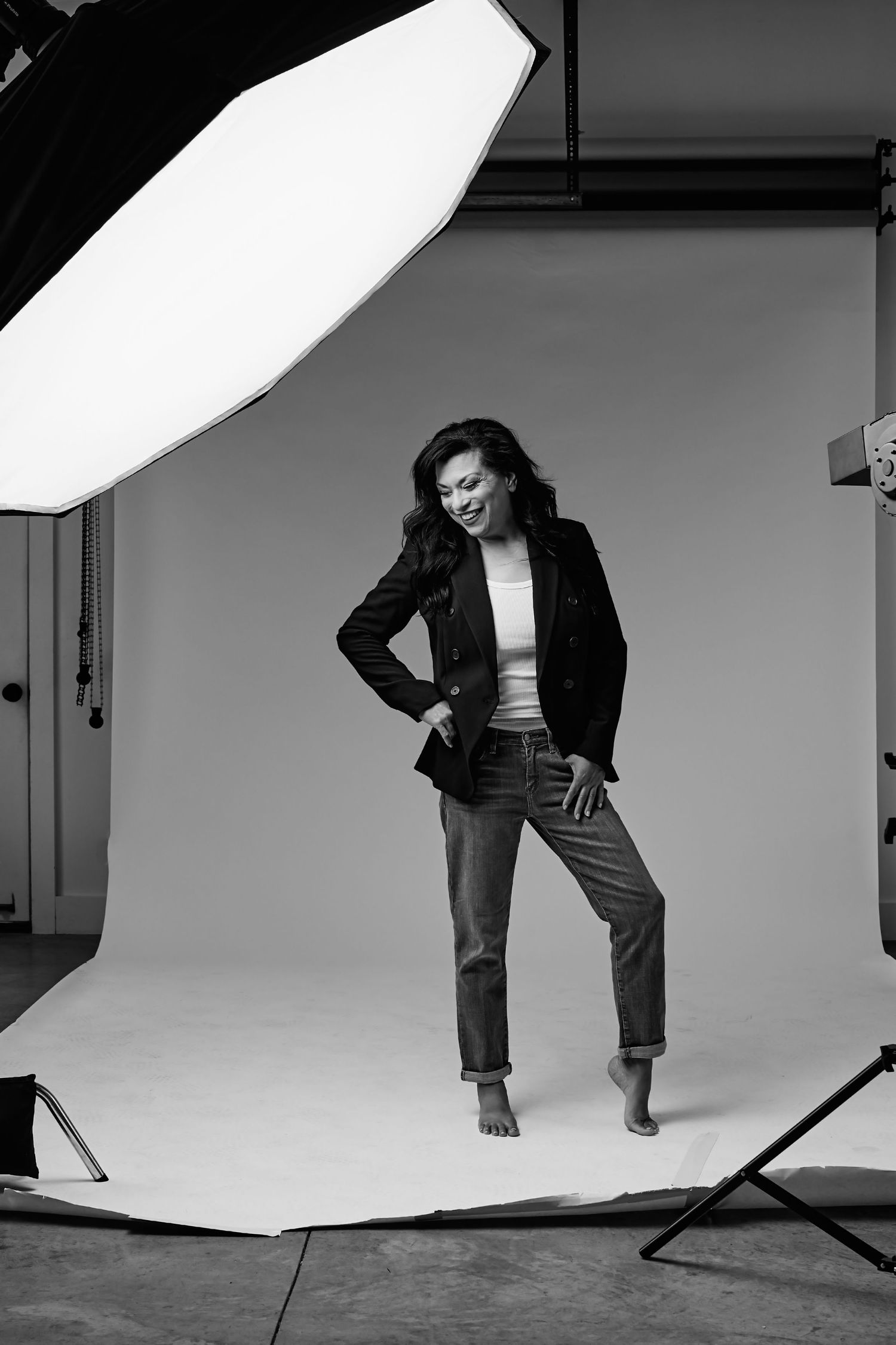 Studio portrait with professional lighting showing business casual attire against white background.