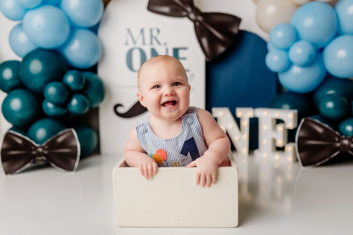 Baby photo shoot with vintage theme featuring red tricycle and rustic props.