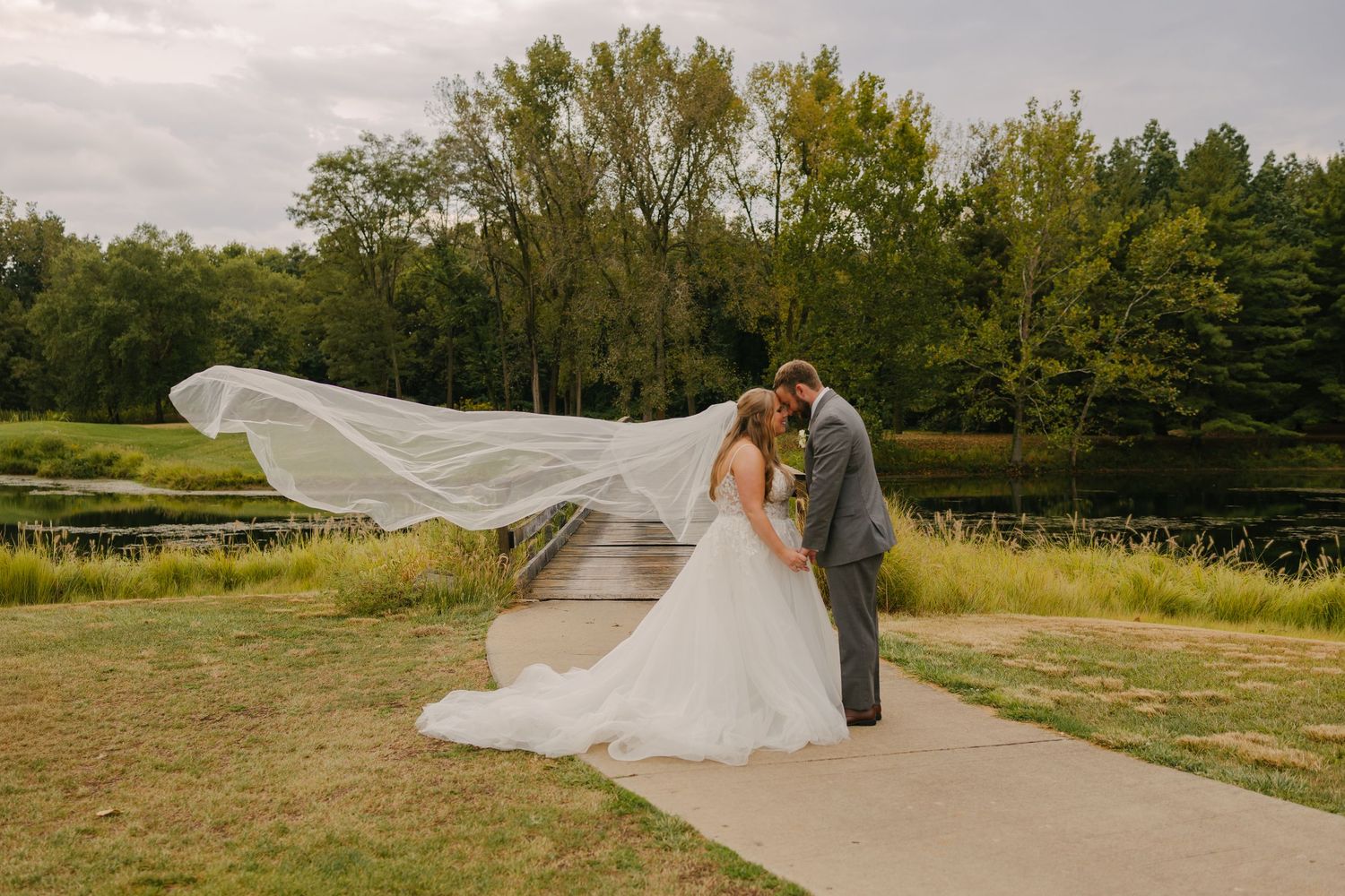 A tender moment between a couple near a window with white curtains.
