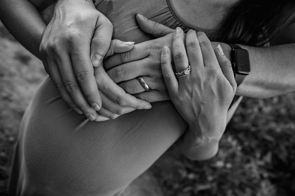Close-up black and white photos of hands holding tenderly.