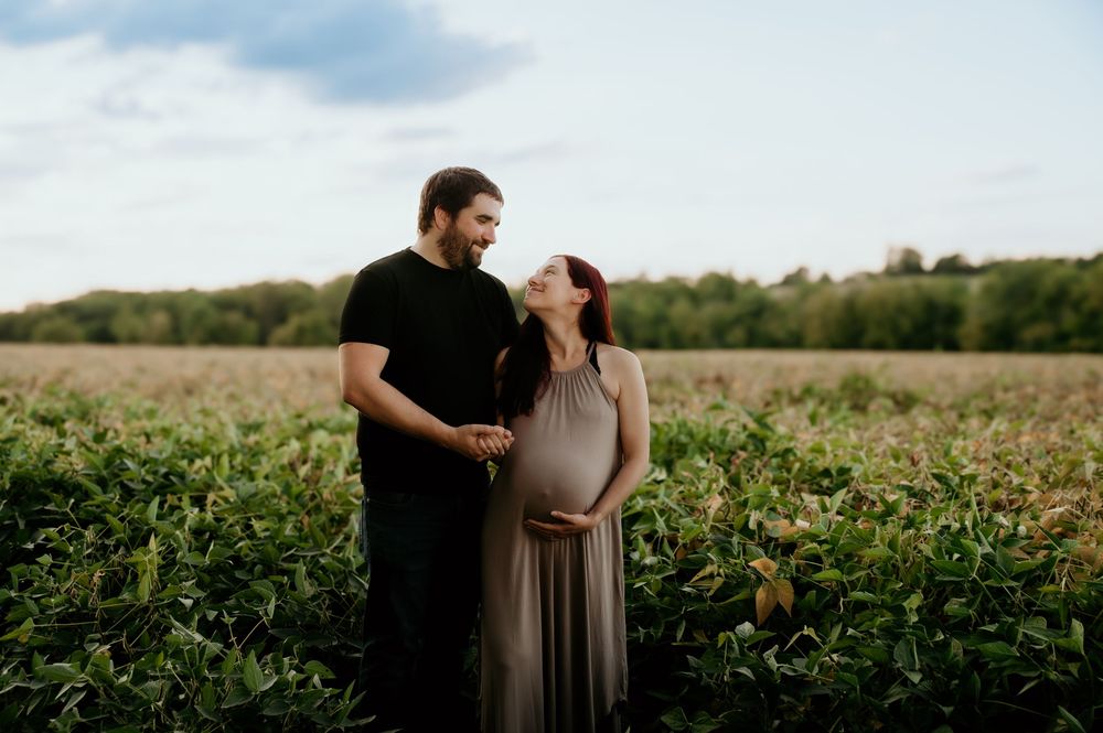 Romantic couple shares a tender moment among rows of green crops.