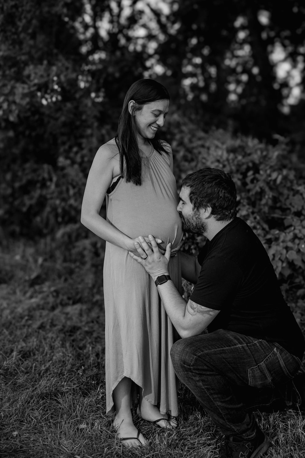 Black and white photo of an intimate maternity moment in a rural setting.