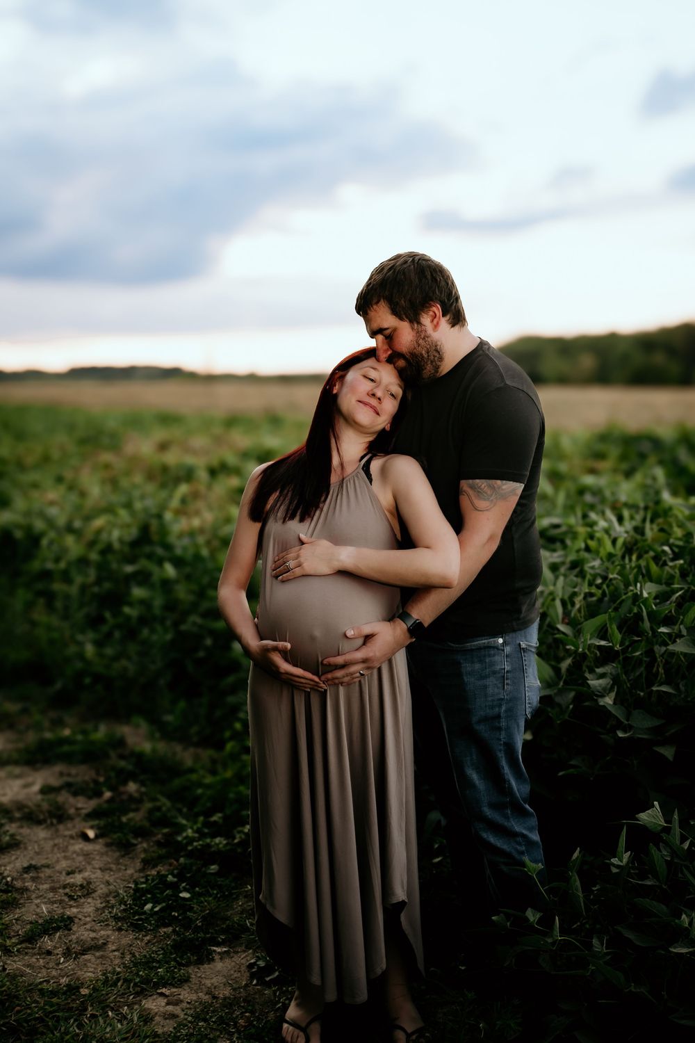 Sweet maternity photo session captured in a scenic crop field.