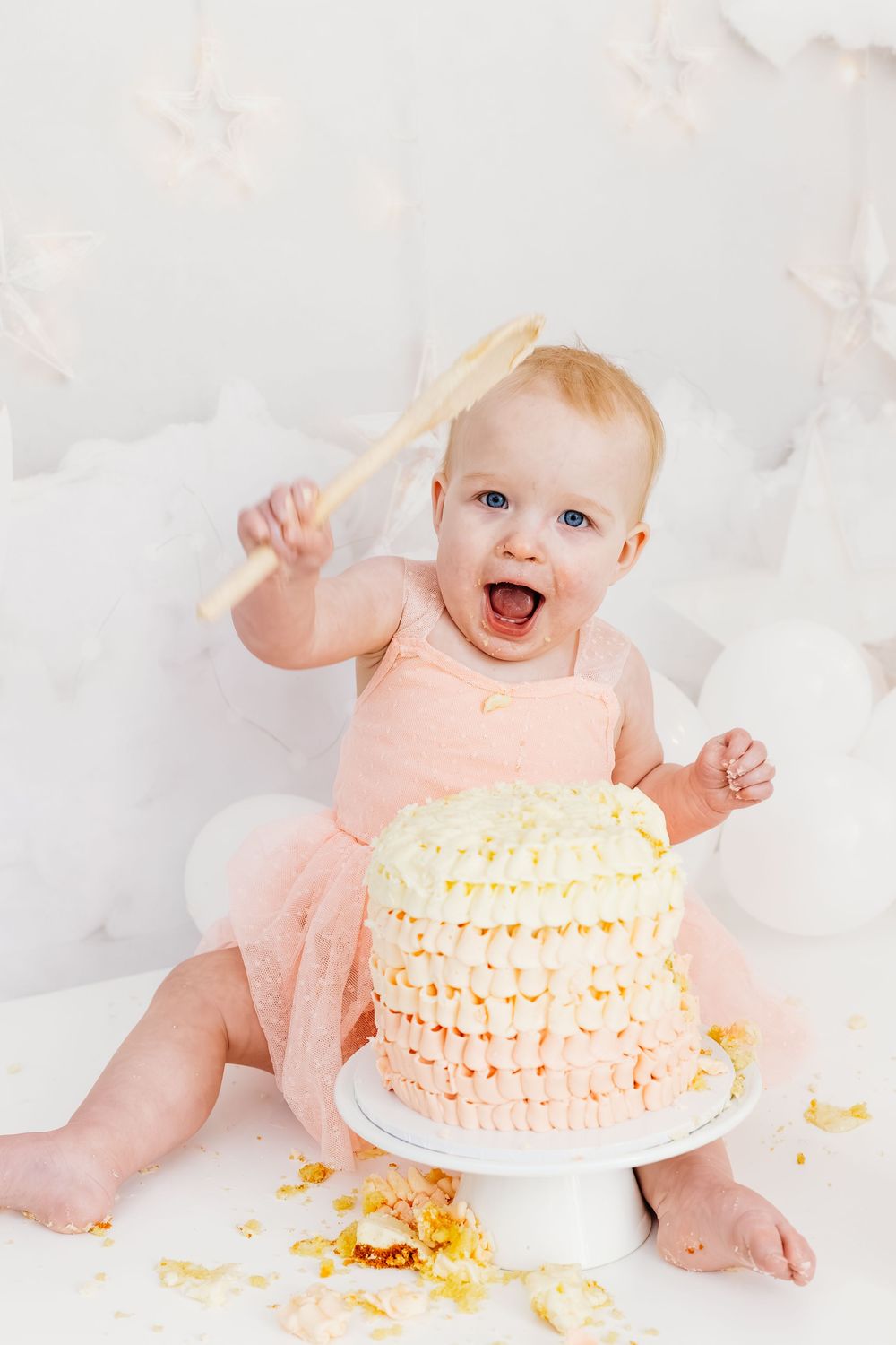 Baby laughing during first birthday photoshoot.