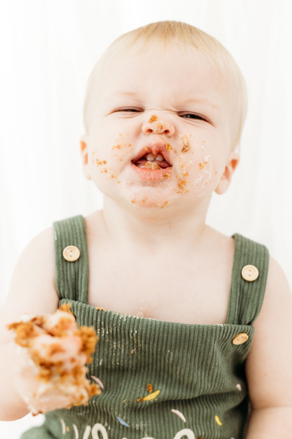 Nottingham cake smash photographer capturing baby covered head-to-toe in icing during fun, messy first birthday session in Mapperley studio.