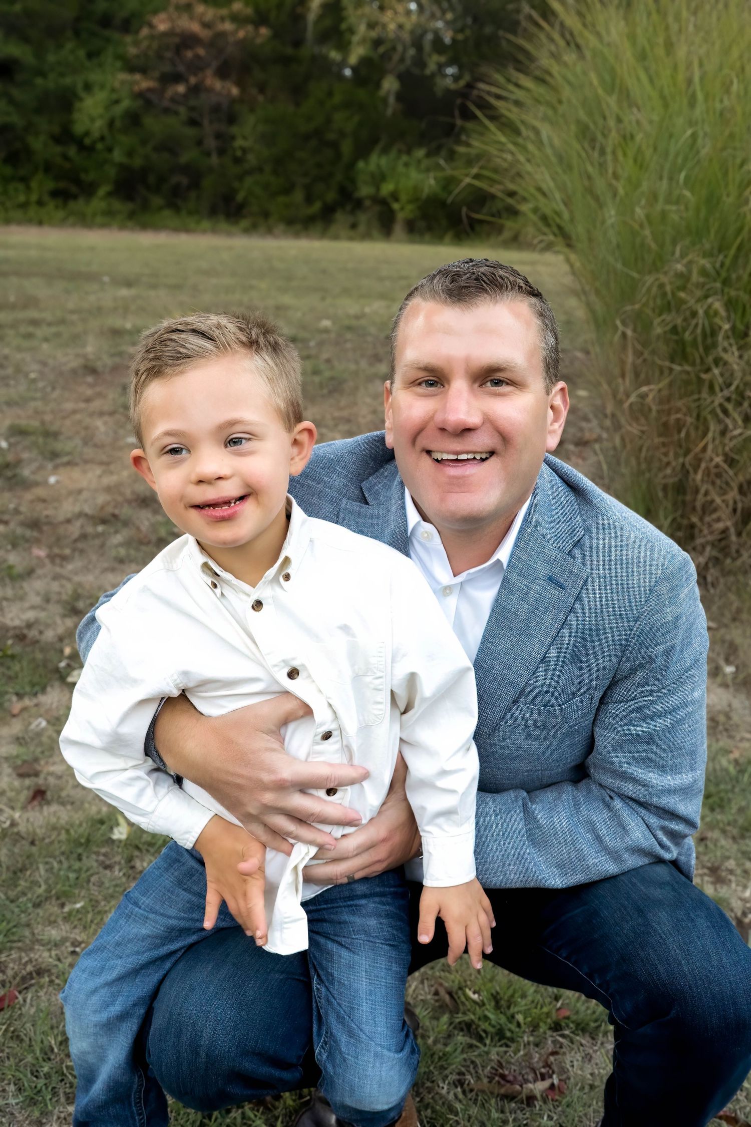 Family portrait featuring coordinated outfits with pink and teal colors against a natural backdrop.