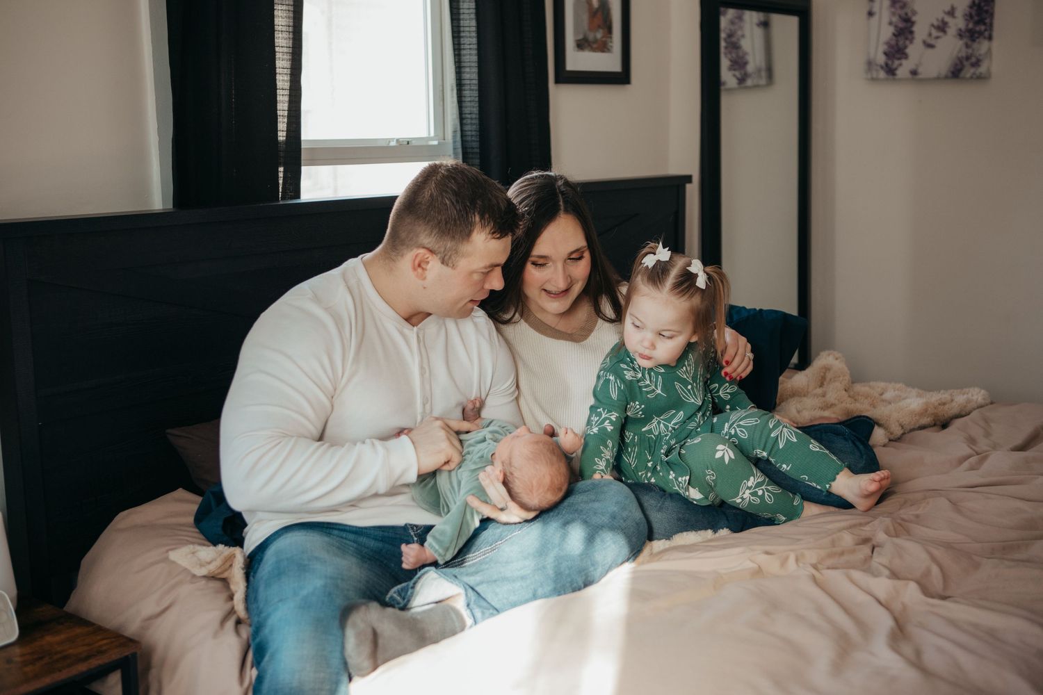 Candid family lifestyle photo of relaxed moment together on bed.