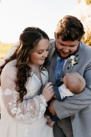 Intimate family moment outdoors during golden hour with a newborn baby.