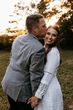 Intimate couples portrait during golden sunset in outdoor setting.