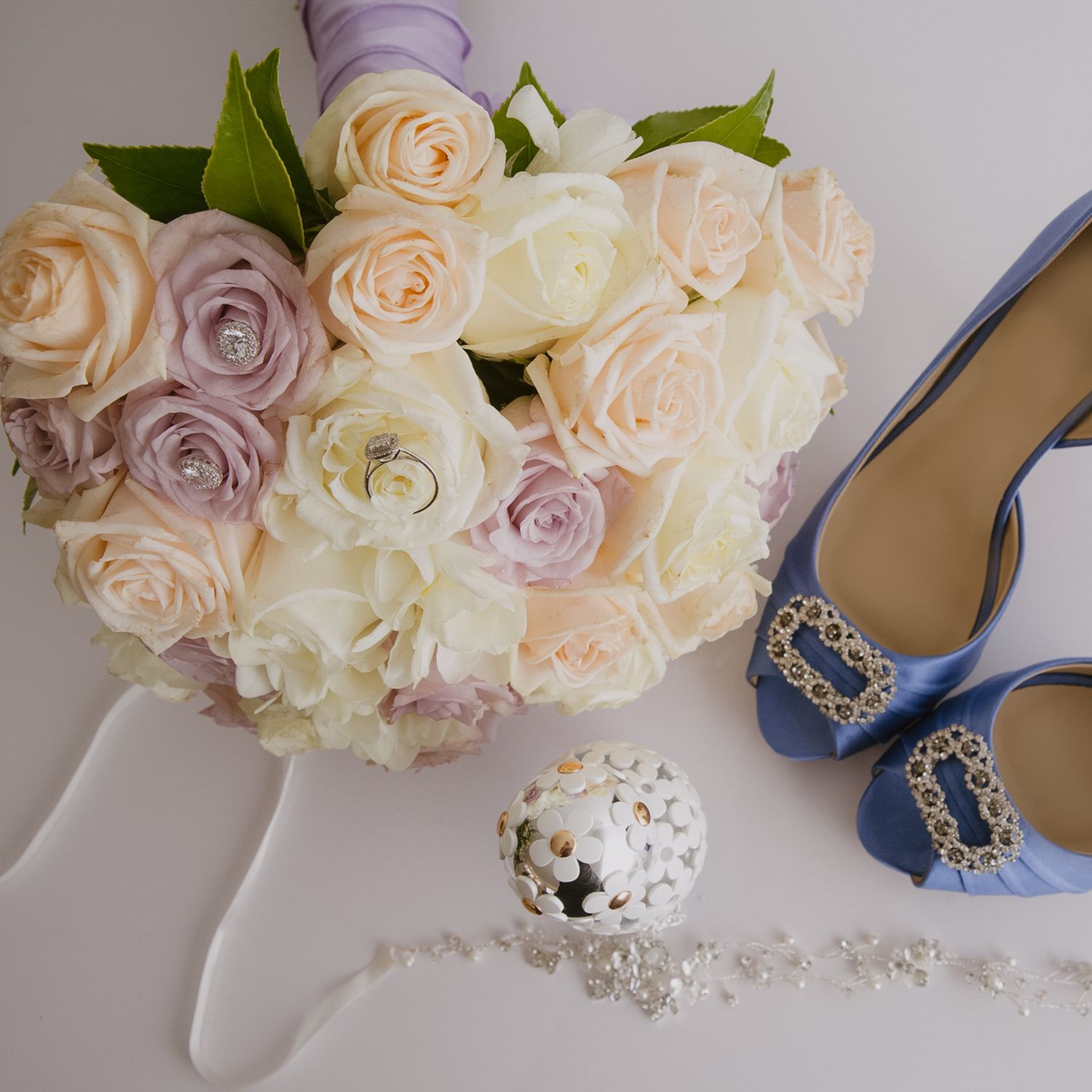 Bridal detail shot of blue embellished peep-toe heels, rose bouquet, and perfume, Norfolk wedding photographer.
