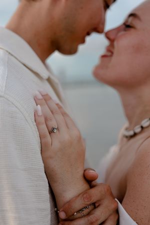 Close-up photo series of couple's hands wearing engagement ring in soft natural lighting.