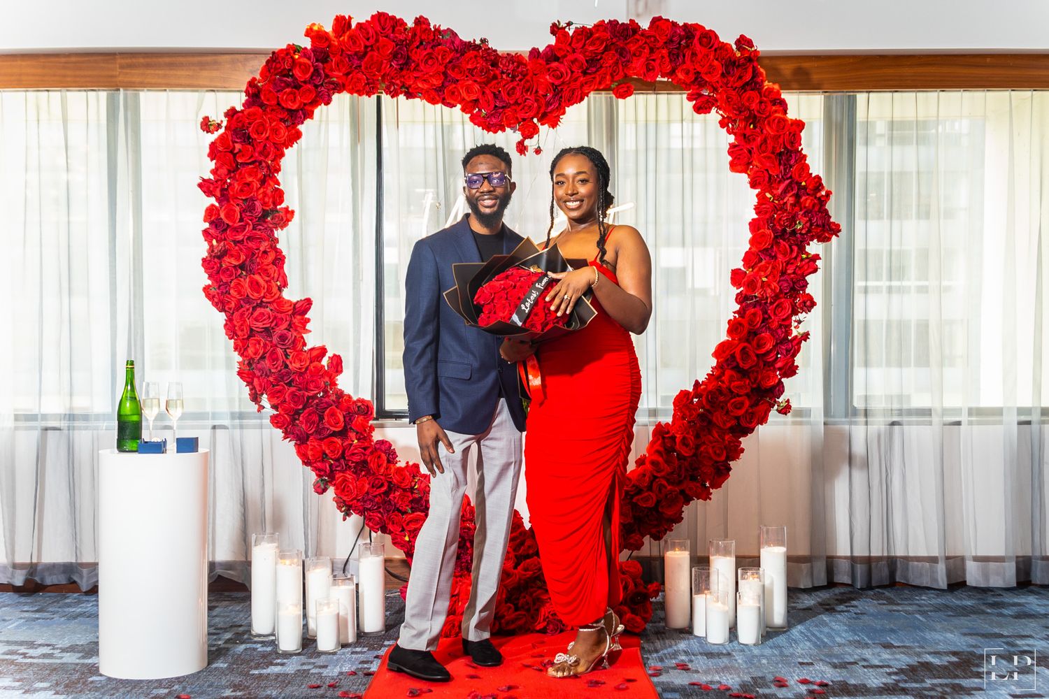 Red rose heart-shaped arch creates romantic wedding ceremony backdrop.
