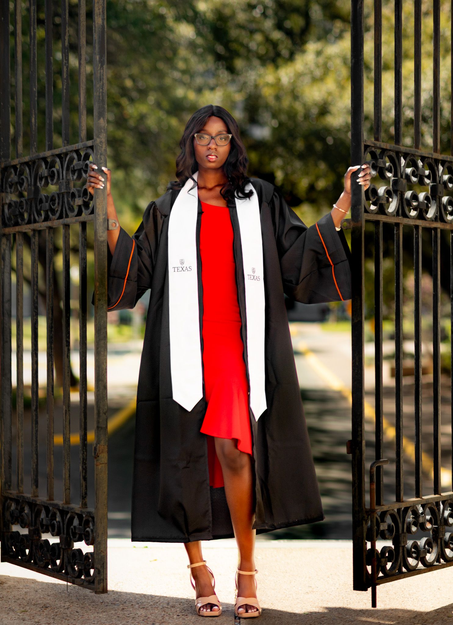 A graduation photo series featuring someone in a cap and gown posing by ornate gates.