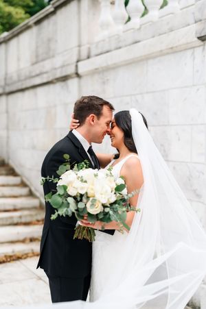 A romantic wedding photoshoot sequence showing a couple kissing with a flowing white veil and bouquet of white flowers.