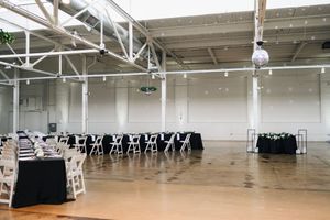 Large empty warehouse interior with white walls and exposed ceiling beams showing industrial storage space.