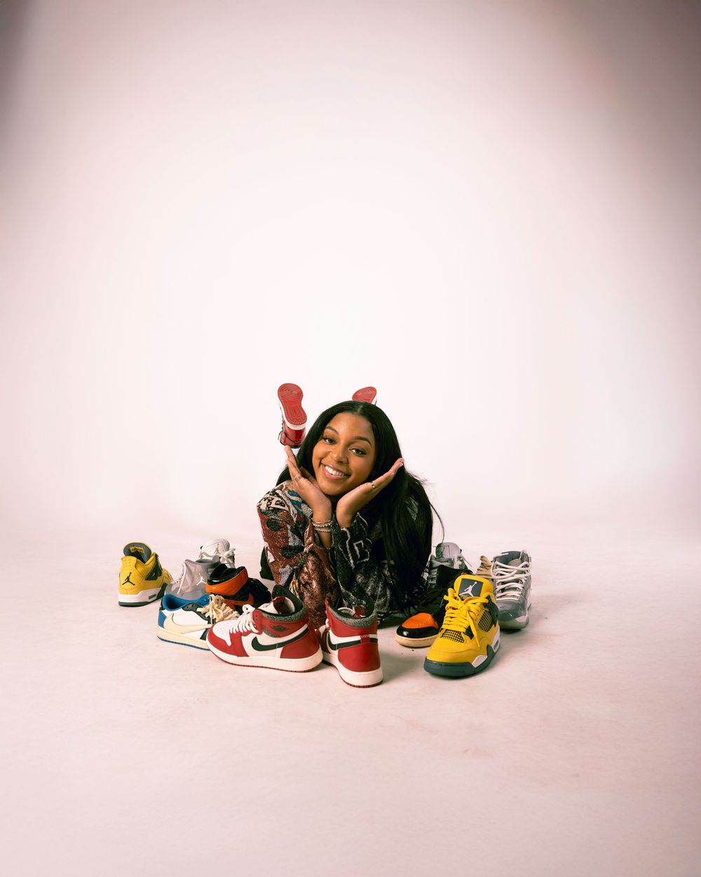 Collection of colorful sneakers arranged in a minimalist style against a light background with soft vignette effect.