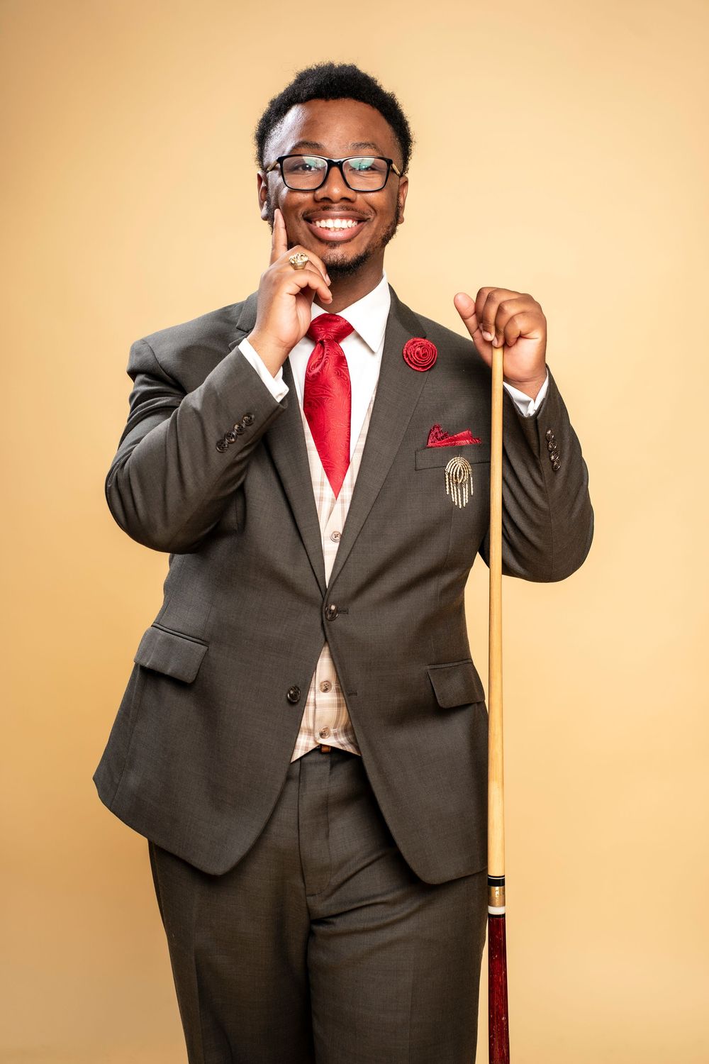 Professional portrait series showing a person in a dark suit and red tie striking different confident poses against beige background.