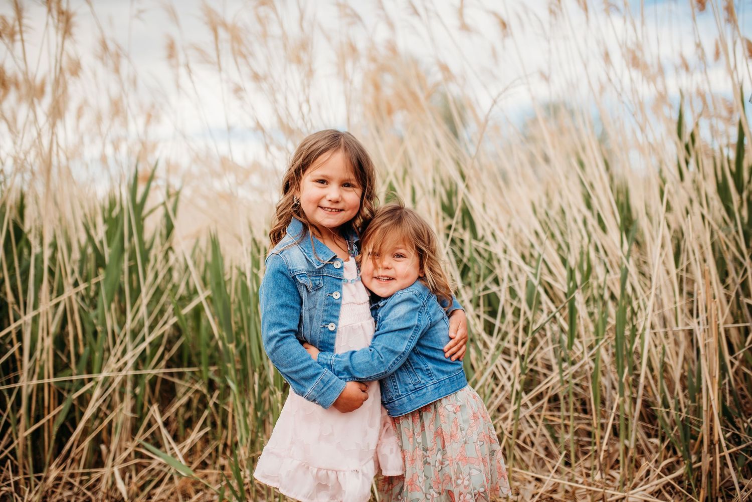 A tender moment shared between parent and child playing together in a lush green meadow on a spring day.