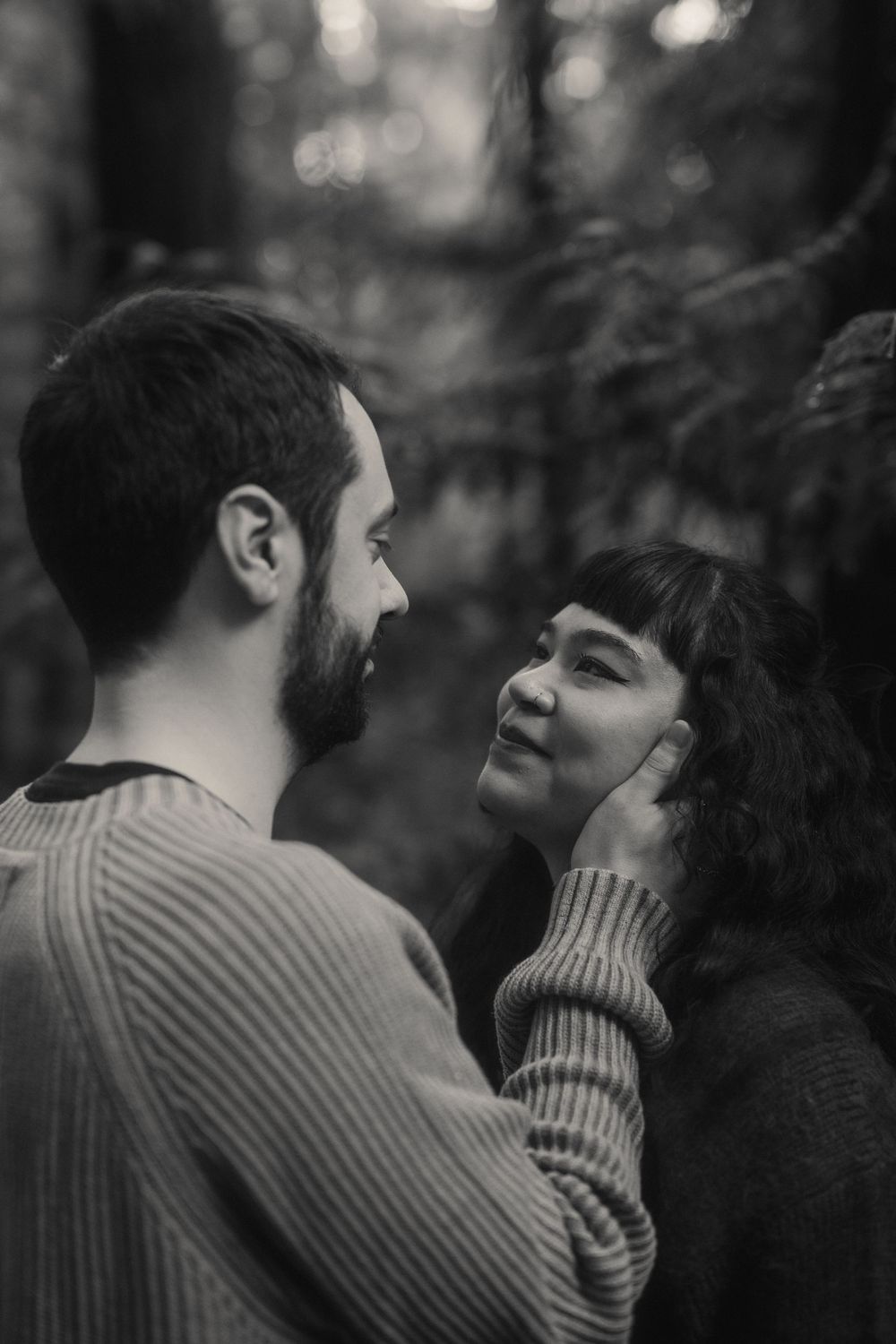 Black and white photo series showing a tender romantic moment between two people in a knit sweater outdoors.