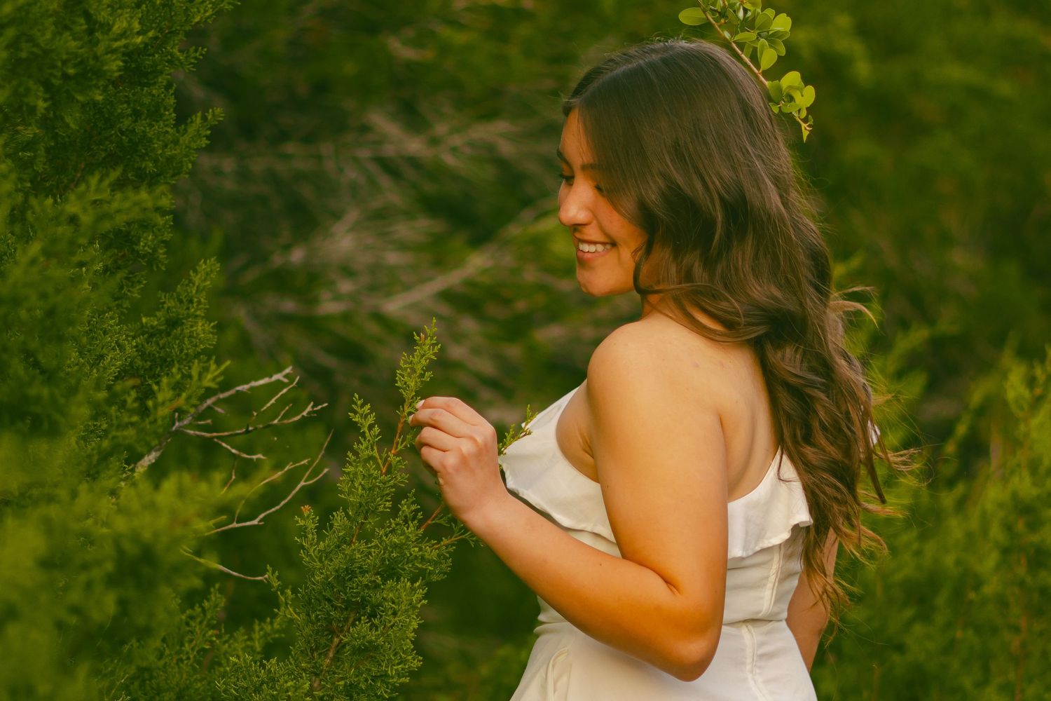 Person in white dress walking through field during golden hour.