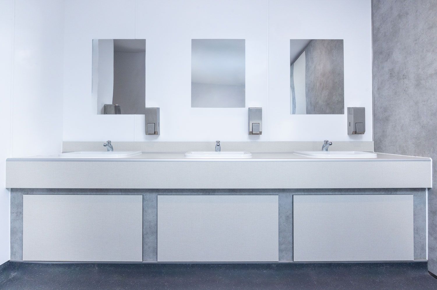 Close-up architectural documentation of commercial washroom hardware and finishes, focusing on material integrity and technical installation
