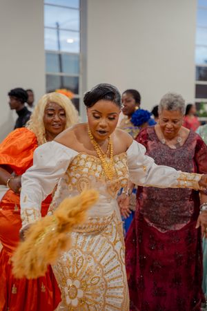 Dancers in colorful traditional dresses perform a lively celebration dance with expressive movements.