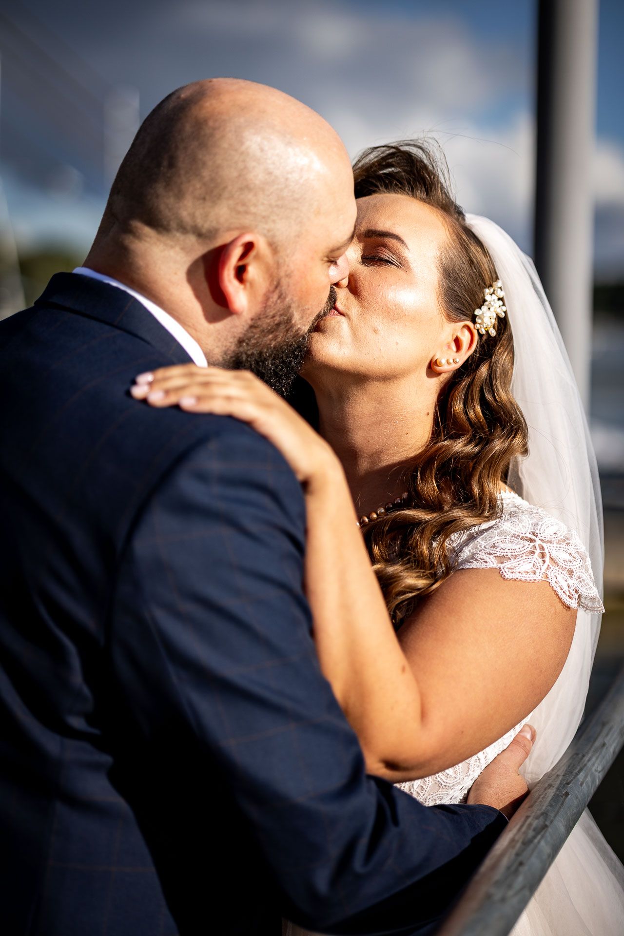 Romantic moment between newlyweds on a sunny day by the water.