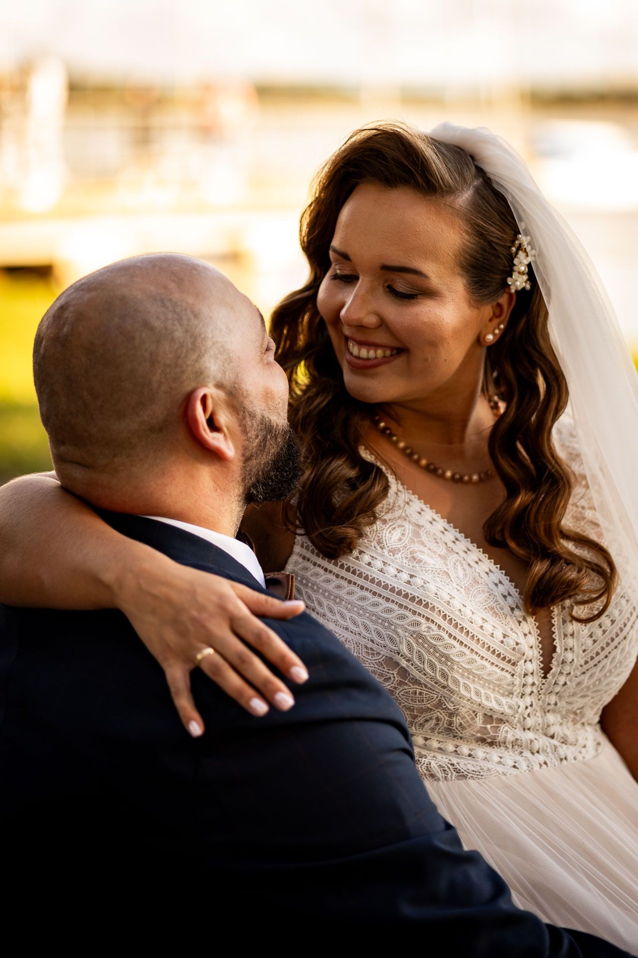 Tender moment between newlyweds embracing in soft natural light.