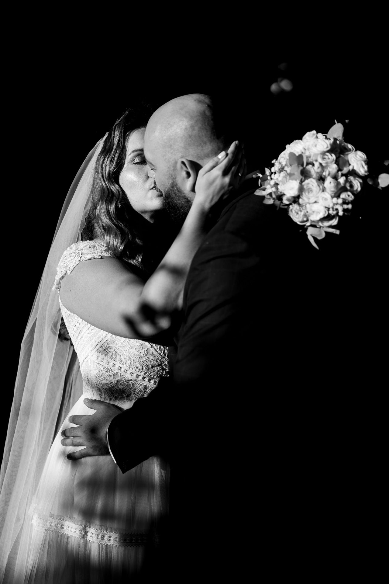 Dramatic black and white wedding portraits with elegant lighting and shadows.