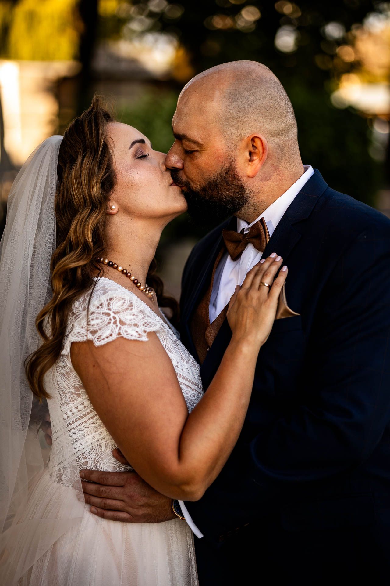 Intimate wedding portraits captured during golden hour in a garden setting.