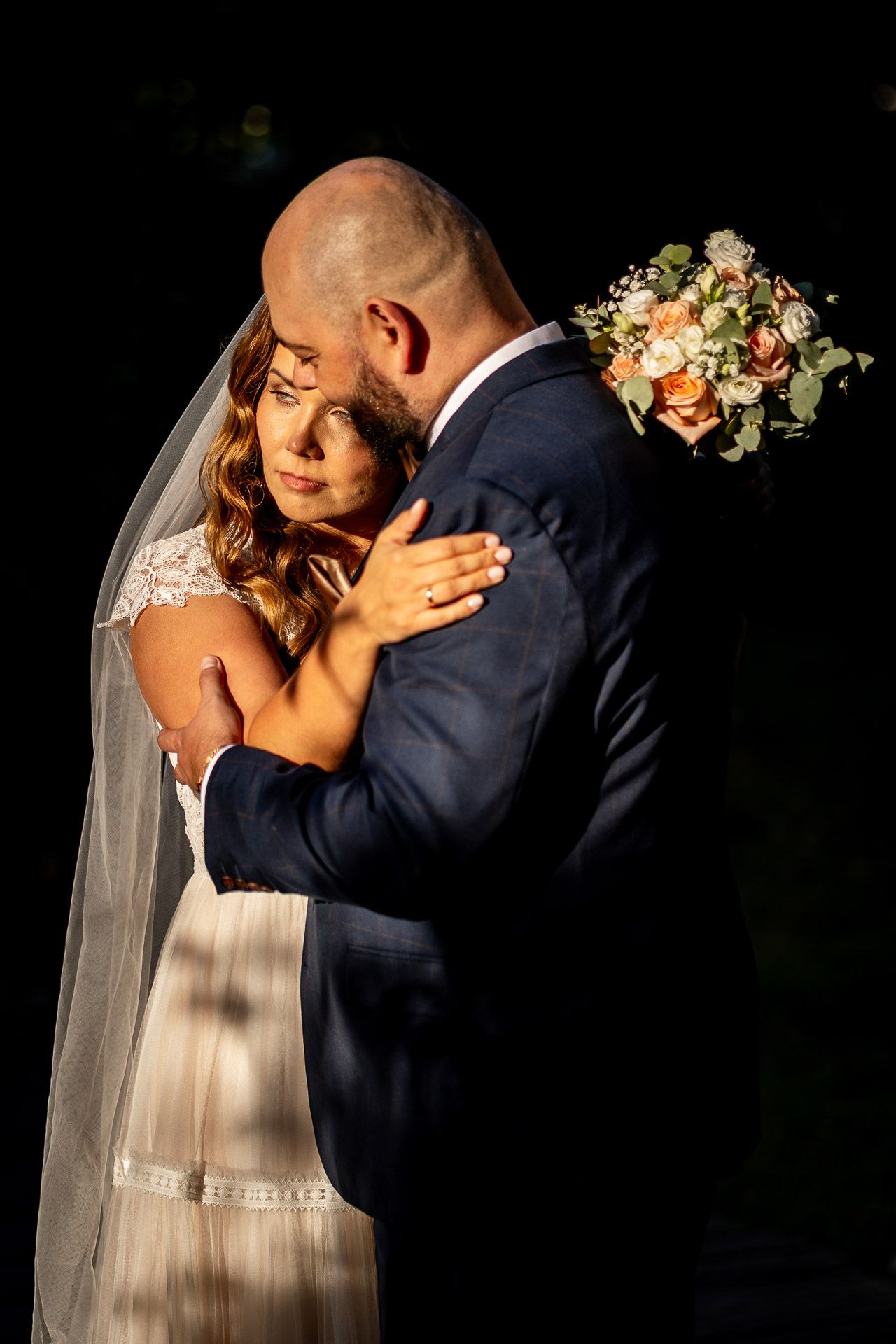 Intimate wedding portraits with dramatic lighting showing tender moments between newlyweds.