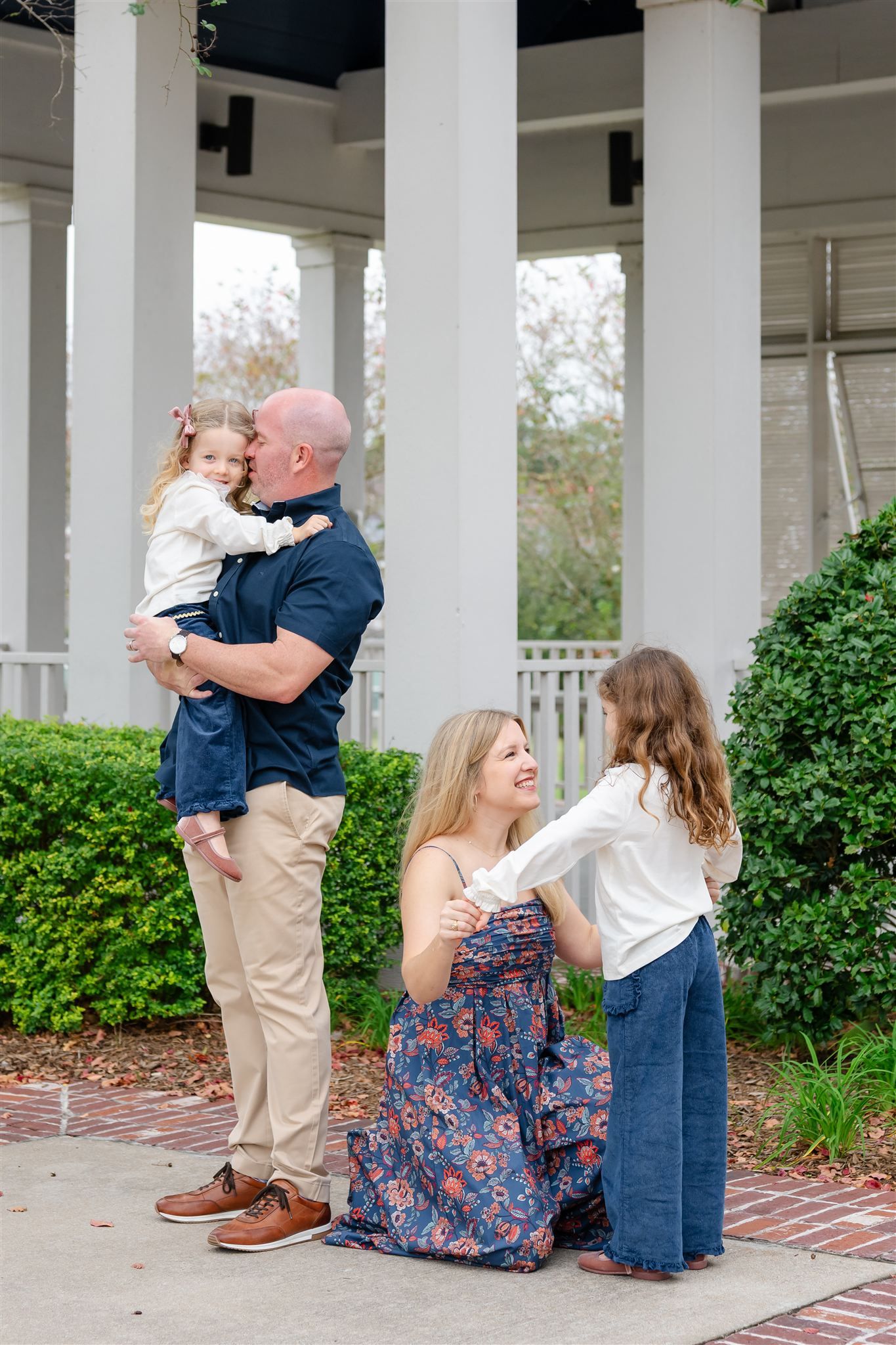 A family shares a tender moment together on a porch in Conroe, texas.