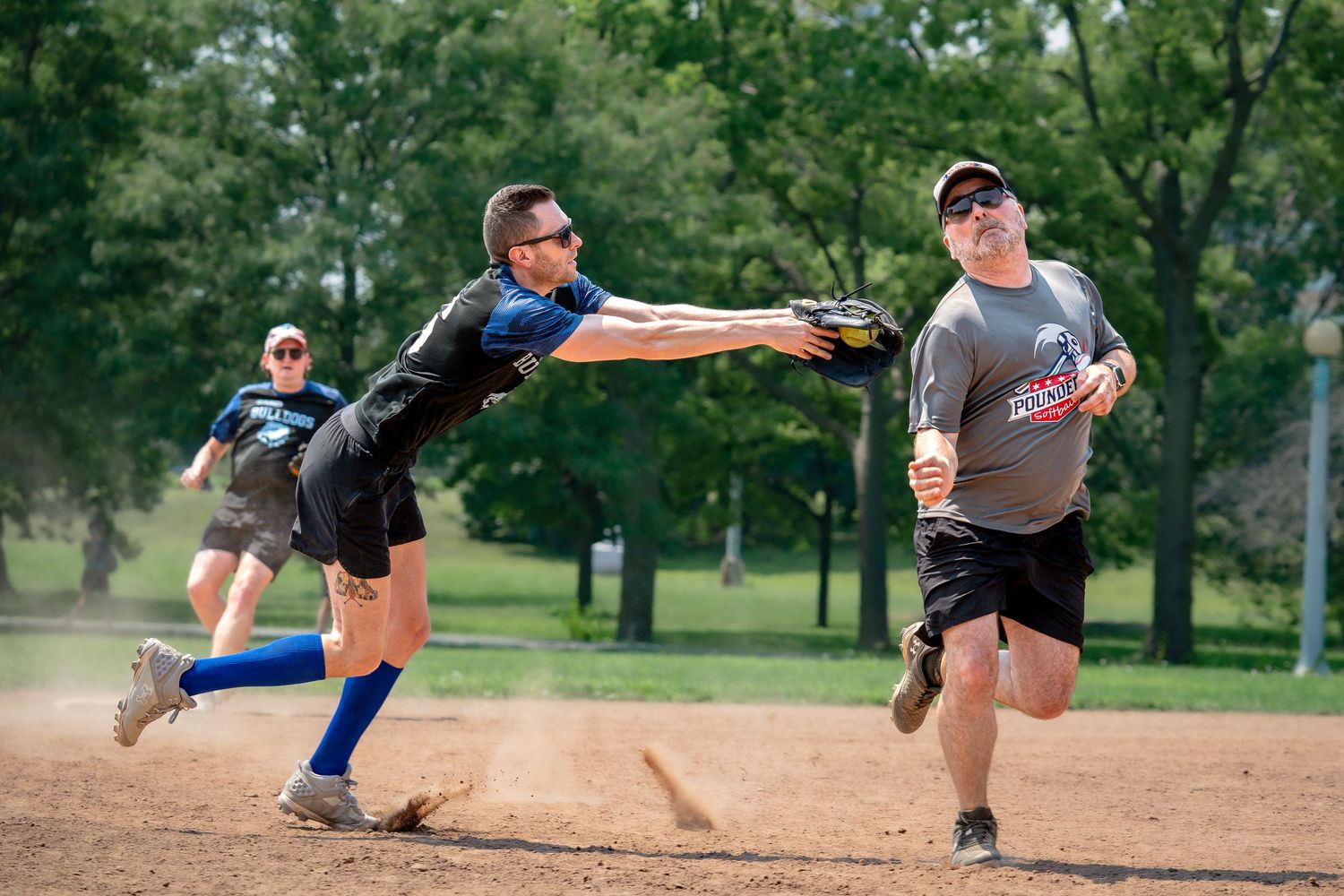 A baserunner in a softball game successfully dodges a tag from an infielder