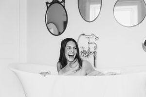Three black and white photos show a person in a bathtub expressing different emotions and poses.