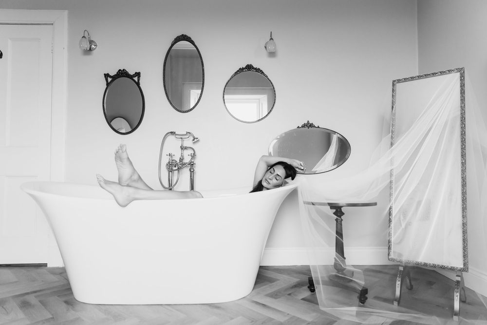 A series of six minimalist black and white bathroom scenes showing bathtubs and fixtures in modern settings.