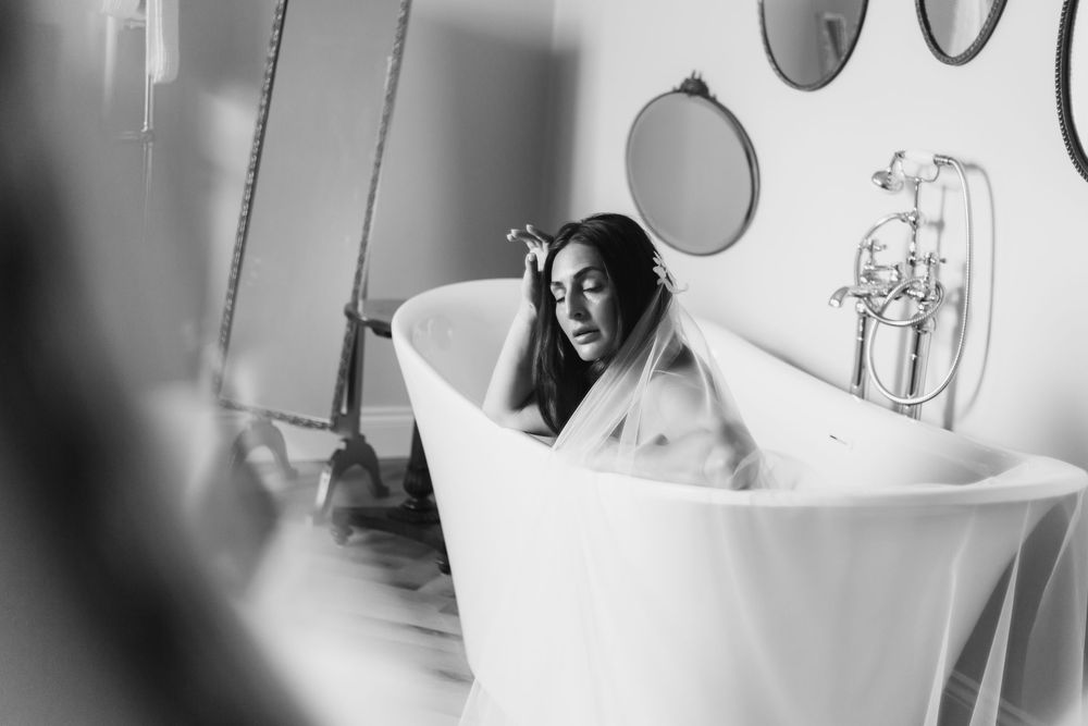 Black and white photo series showing intimate moments of a newborn baby's first bath in a hospital setting.