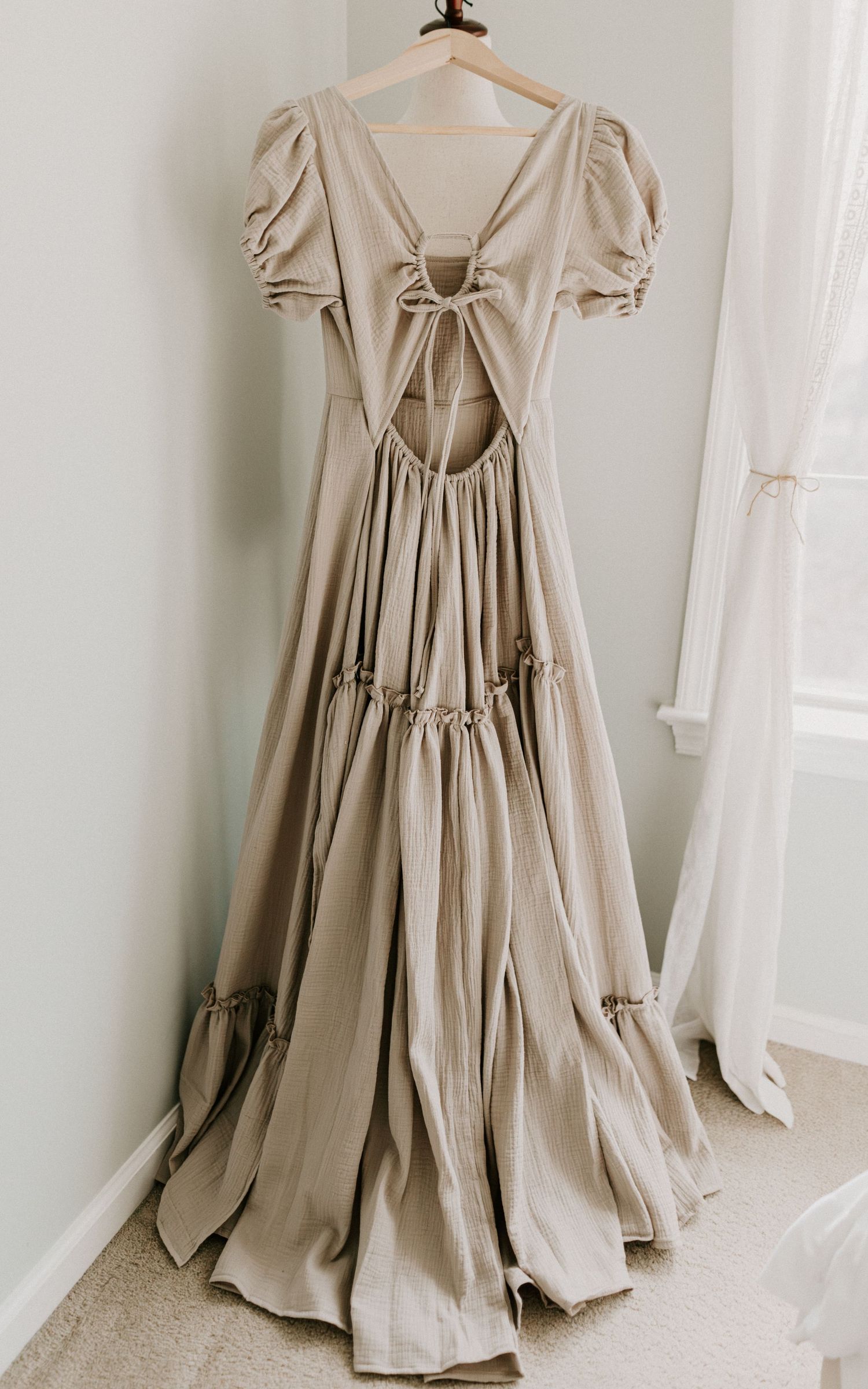 Vintage cream-colored peasant dress with puff sleeves and corset back lacing displayed on mannequin from multiple angles.