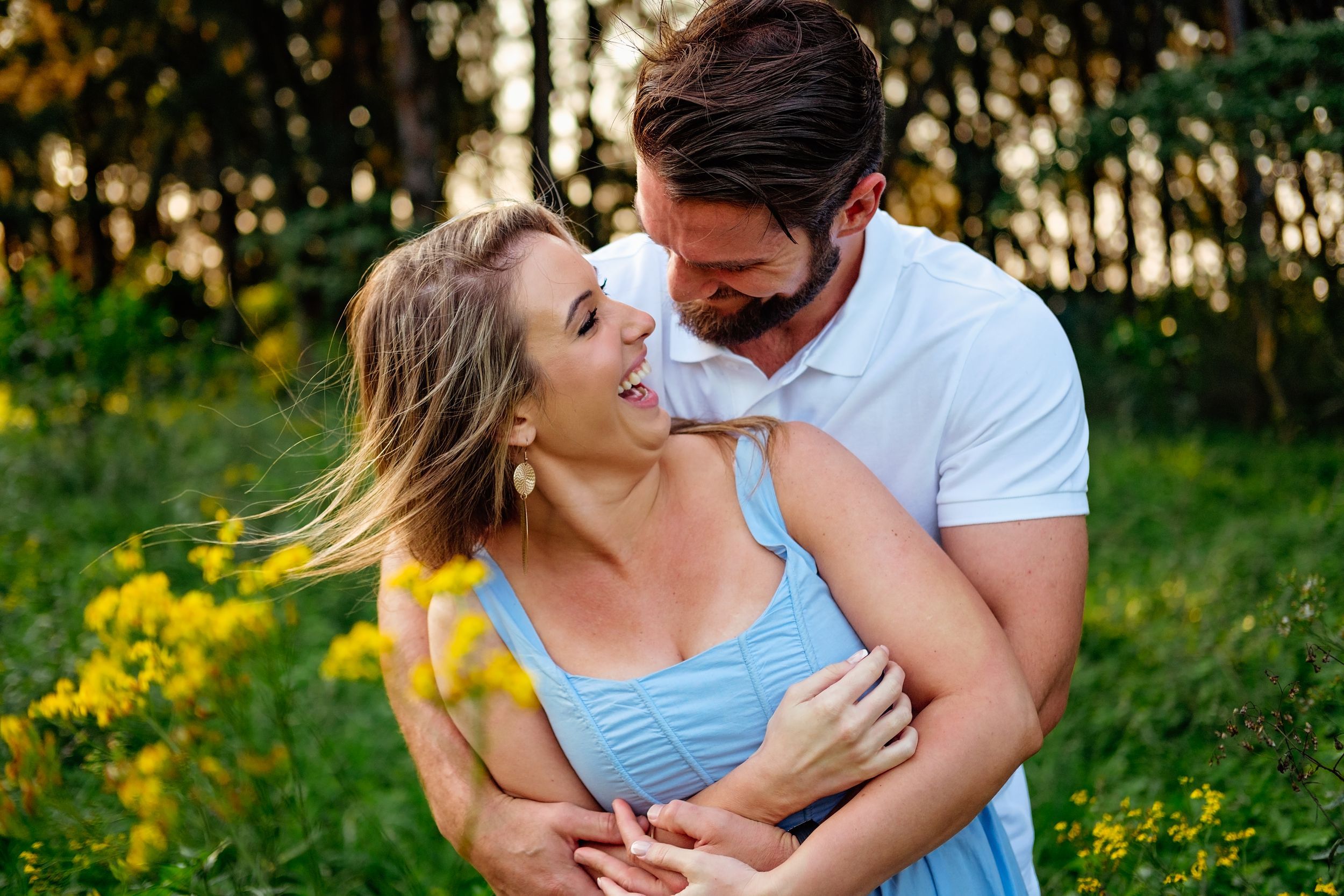 Couple laughing together in a forest during a natural shoot