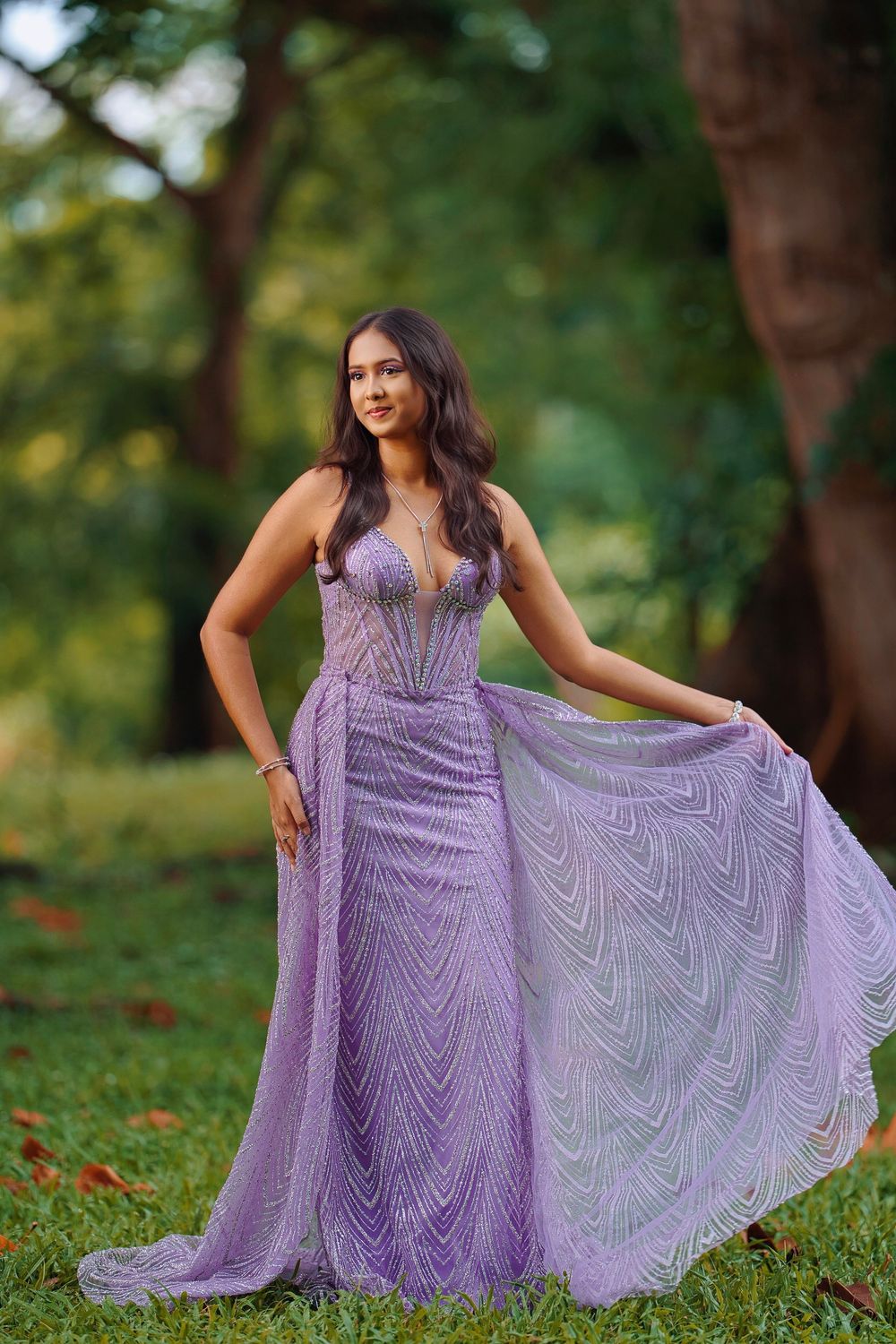 A stunning lavender formal gown with intricate beading sparkles in an outdoor garden photoshoot.