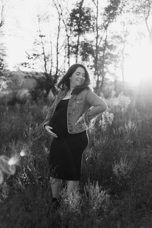 Black and white artistic photo series of a person in dark clothing dancing freely in a meadow at sunset.